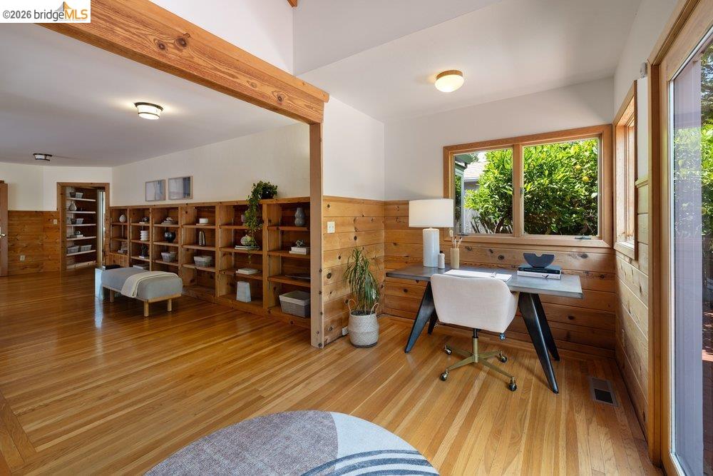 287 Purdue Avenue Kensington, CA 94708 - Photo 30 of 60 Wood-finish flooring throughout, featuring extensive built-in shelving, natural wood wainscoting, and large windows with outdoor scenery