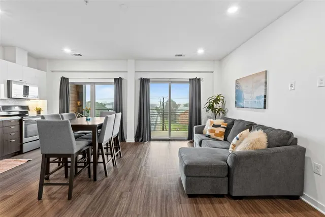a living room with furniture wooden floor and a floor to ceiling window