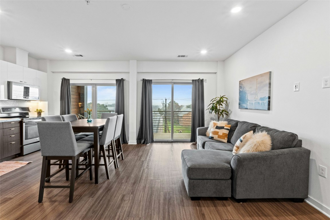 a living room with furniture wooden floor and a floor to ceiling window