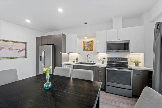 a kitchen with stainless steel appliances granite countertop a refrigerator stove top oven and sink