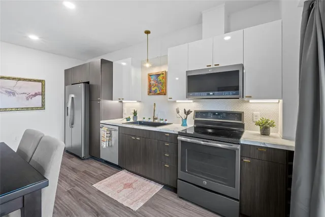 a kitchen with stainless steel appliances a stove microwave and refrigerator