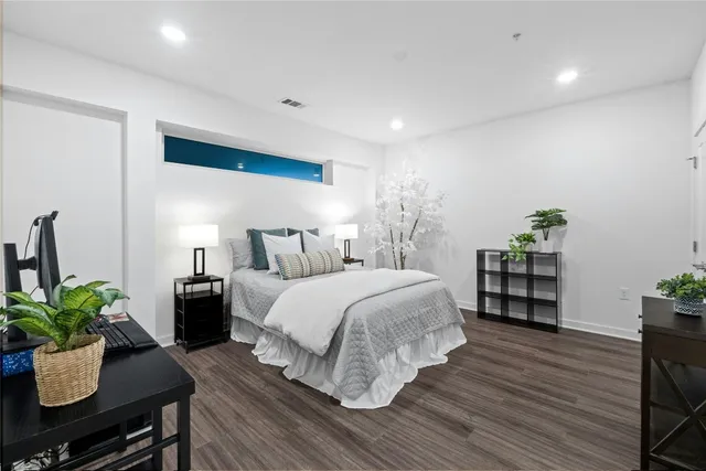 a bedroom with a bed and wooden floor