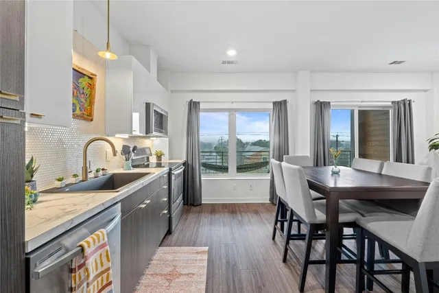 a kitchen with granite countertop a table chairs stove and sink