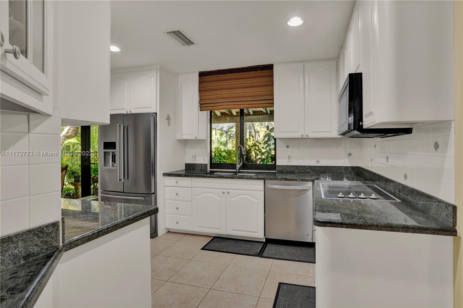 8695 Southwest 110th Street Miami, FL 33156 - Photo 12 of 54 a kitchen with granite countertop a refrigerator and a stove top oven