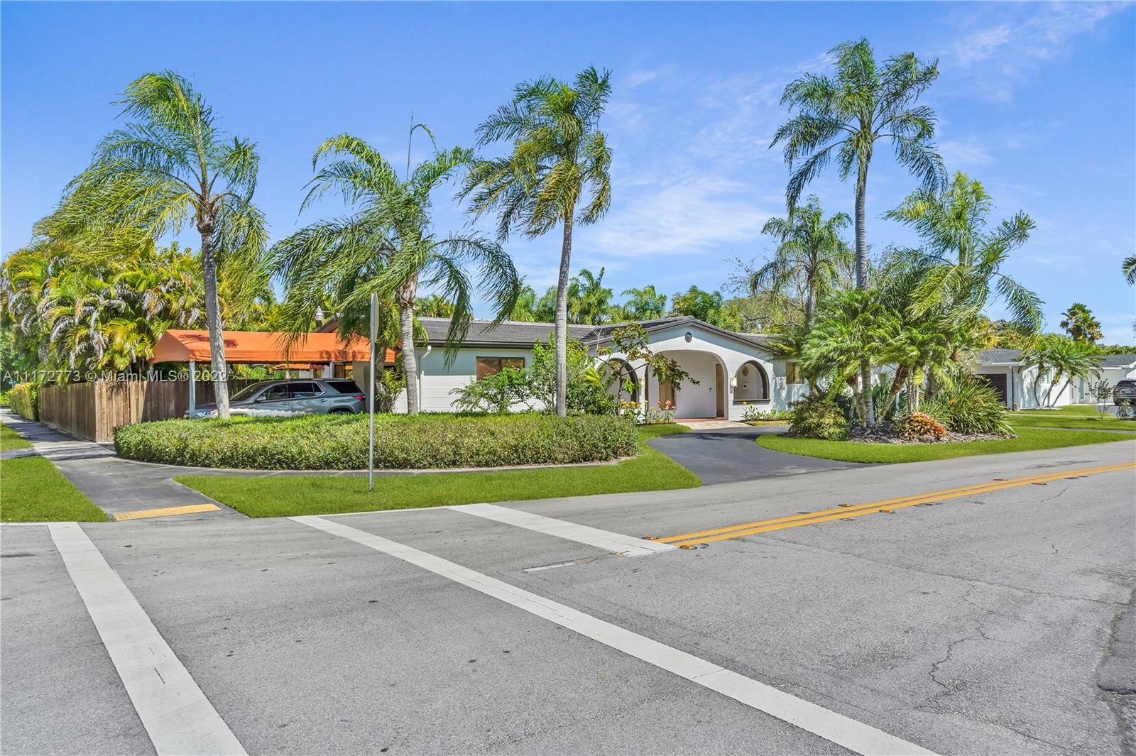 8695 Southwest 110th Street Miami, FL 33156 - Photo 36 of 54 a front view of a house with a yard and potted plants
