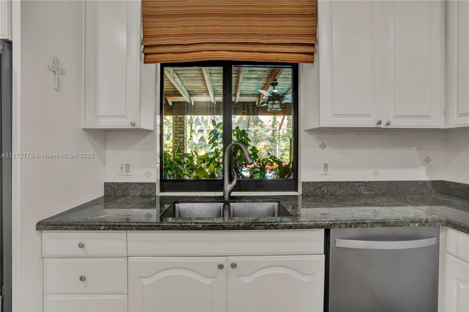 8695 Southwest 110th Street Miami, FL 33156 - Photo 46 of 54 a kitchen with granite countertop a sink and white cabinets