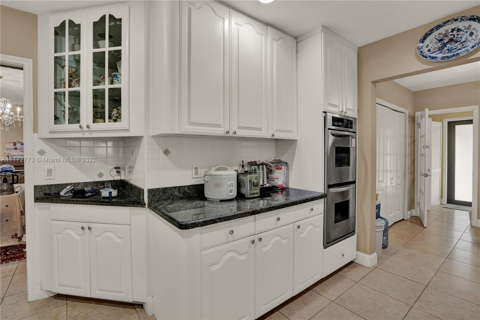 8695 Southwest 110th Street Miami, FL 33156 - Photo 47 of 54 a kitchen with granite countertop white cabinets and sink