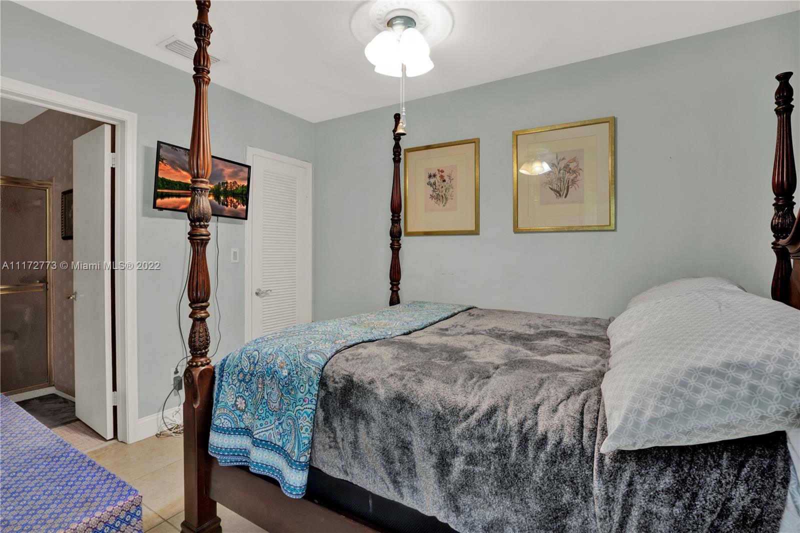 8695 Southwest 110th Street Miami, FL 33156 - Photo 54 of 54 a bedroom with a bed and a chandelier