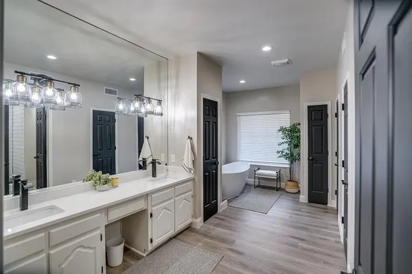 a bathroom with a double vanity sink a large mirror and a shower