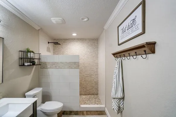 a bathroom with a shower a toilet and a sink