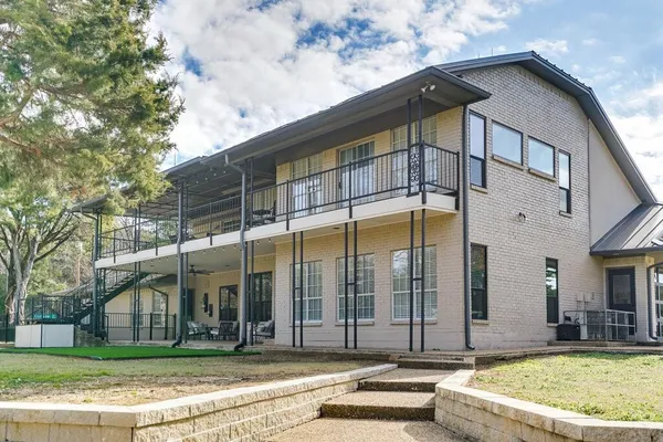 a view of a white building with a small yard