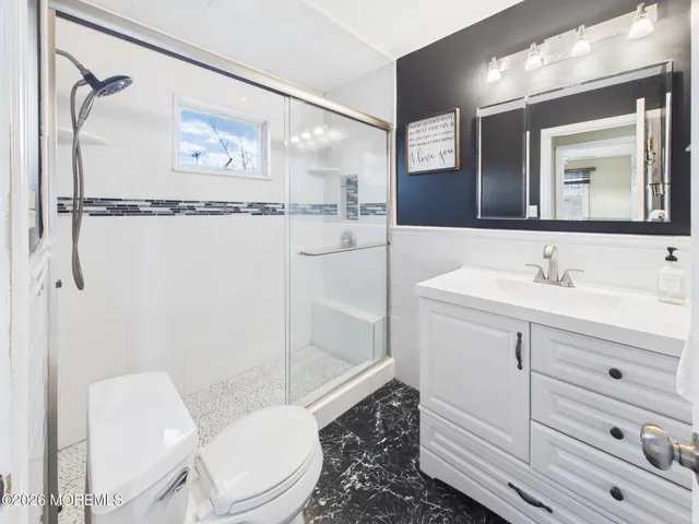 a bathroom with a sink a toilet and shower