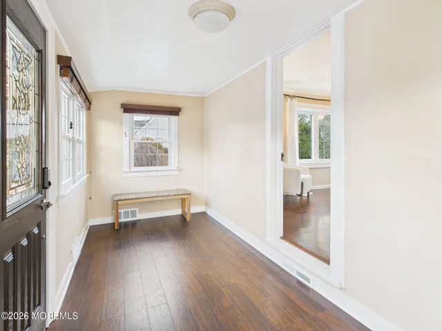 a view of a room with wooden floor and windows
