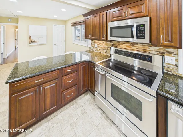a kitchen with granite countertop cabinets stainless steel appliances and wooden cabinets