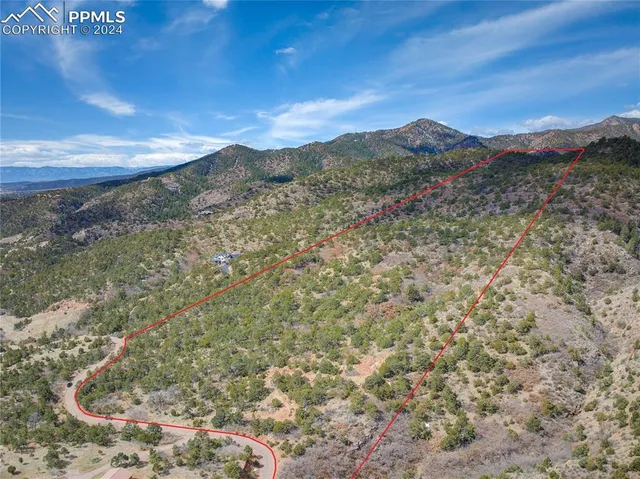 a view of a dry yard with mountains in the background