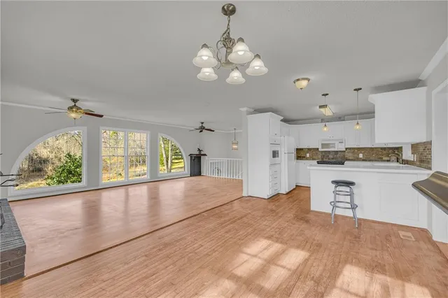 a large kitchen with cabinets and wooden floor