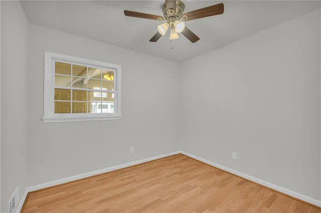 an empty room with a window and a fan