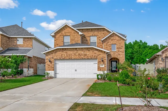 a front view of a house with a yard and garage