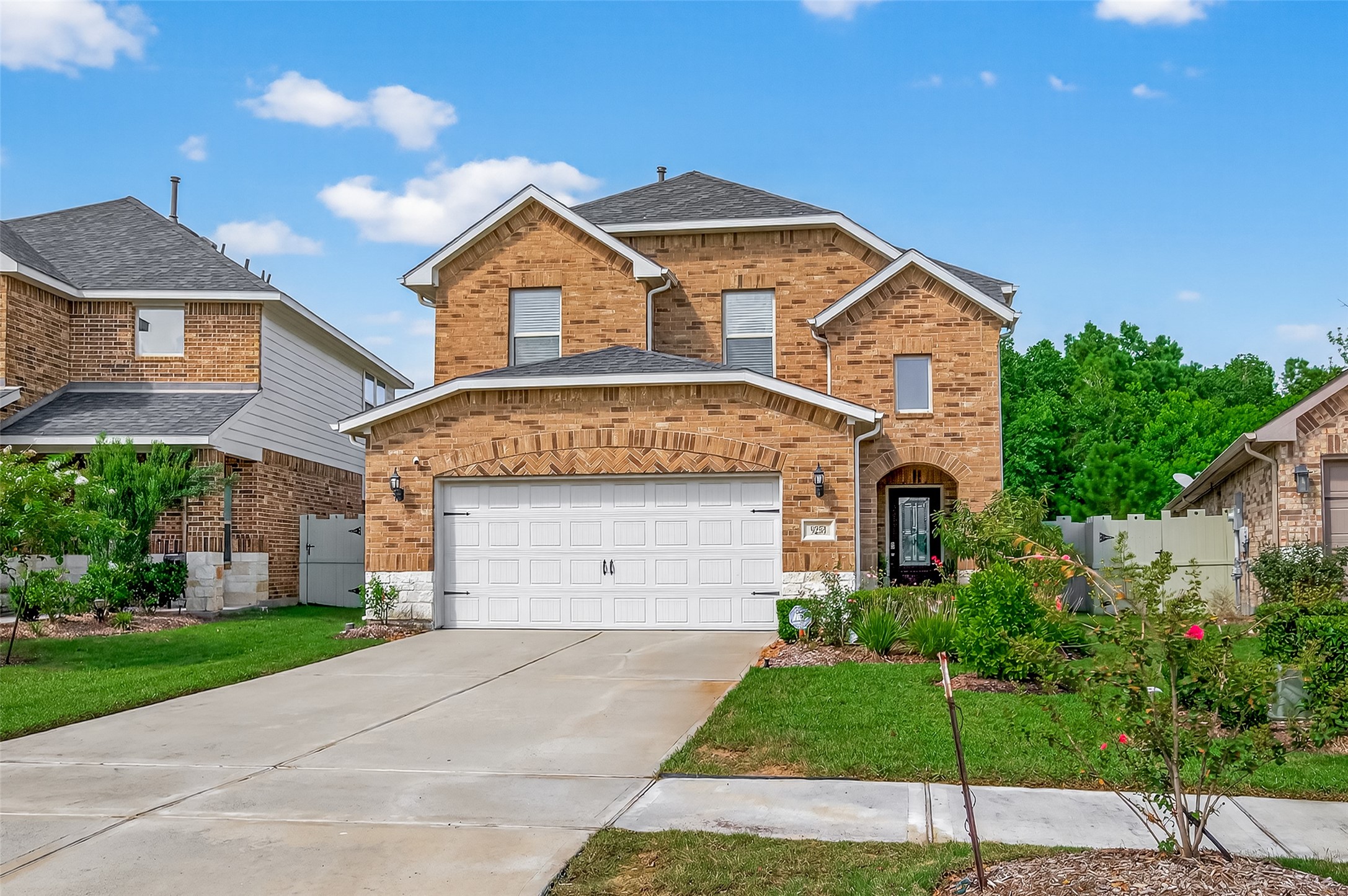 9253 Inland Leather Lane Conroe, TX 77385 - Photo 1 of 34 a front view of a house with a yard and garage