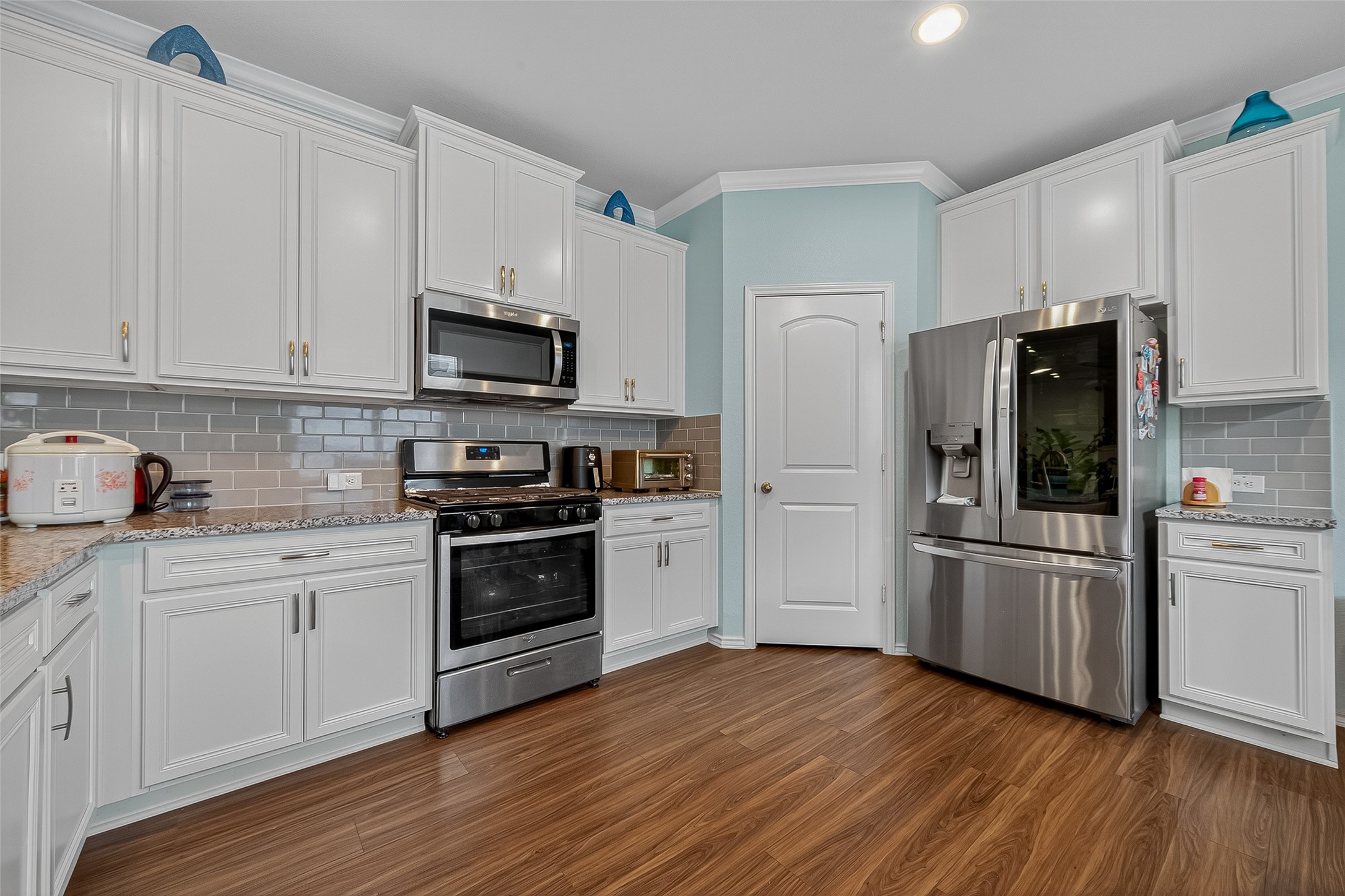 9253 Inland Leather Lane Conroe, TX 77385 - Photo 7 of 34 a kitchen with a refrigerator stove and wooden cabinets