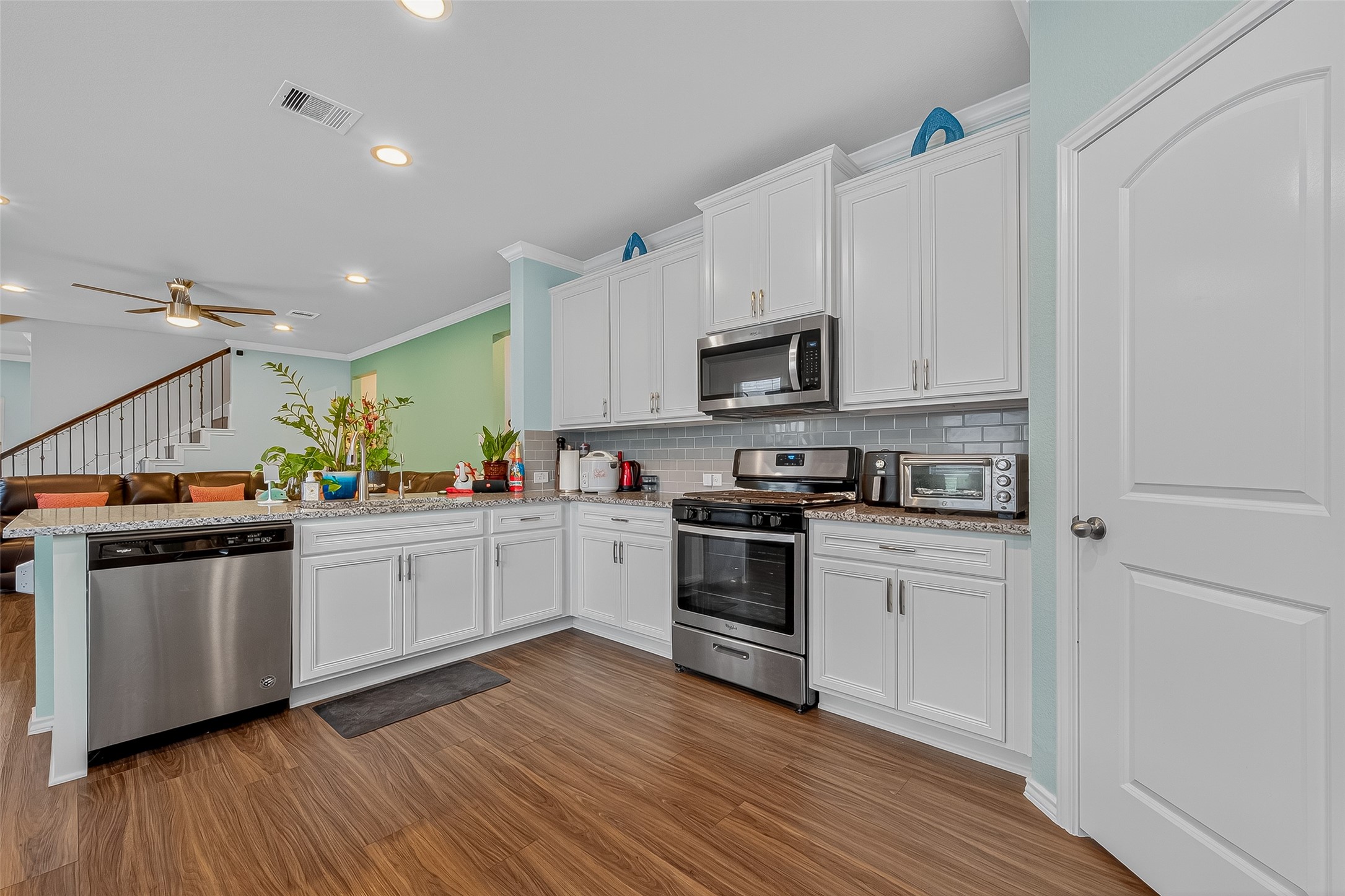 9253 Inland Leather Lane Conroe, TX 77385 - Photo 8 of 34 a kitchen with stainless steel appliances granite countertop a stove top oven a sink and white cabinets