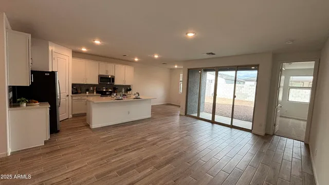 a kitchen with stainless steel appliances a refrigerator a stove top oven and a hard wood floor