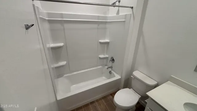 a white toilet sitting next to a bath tub