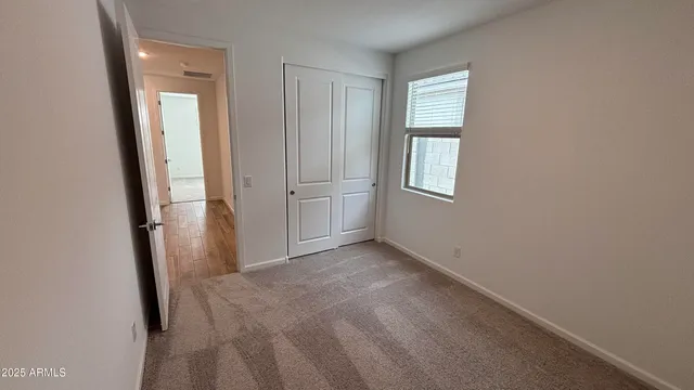 an empty room with windows and closet