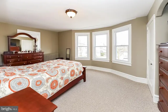 a bedroom with a bed and a lamp on dresser