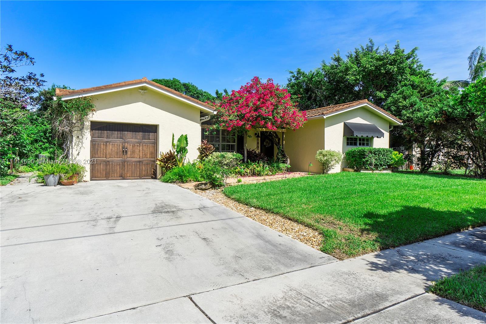 183 Oregon Lane Boca Raton, FL 33487 - Photo 2 of 25 a front view of a house with a yard and garage
