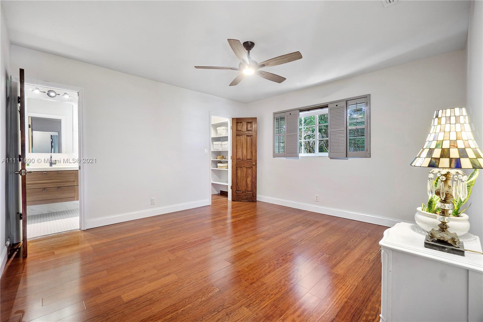 183 Oregon Lane Boca Raton, FL 33487 - Photo 17 of 25 a view of an empty room with wooden floor and a window