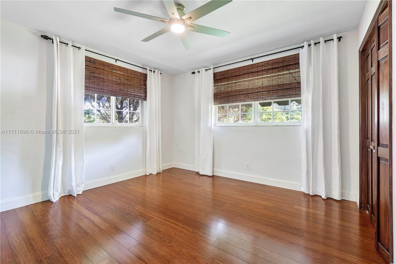 183 Oregon Lane Boca Raton, FL 33487 - Photo 19 of 25 a view of an empty room with wooden floor and a window