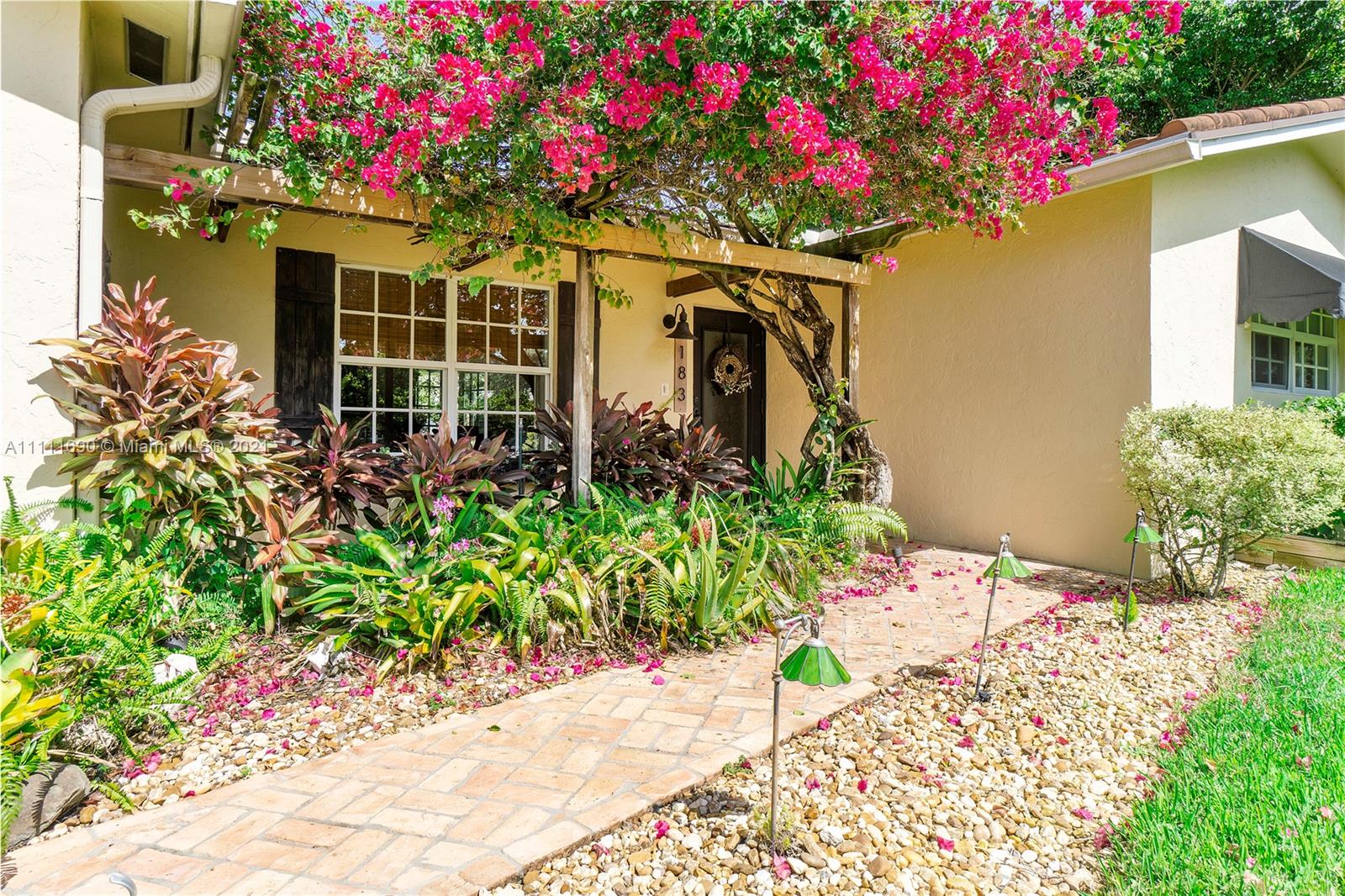 183 Oregon Lane Boca Raton, FL 33487 - Photo 3 of 25 a front view of a house with a lot of flower plants