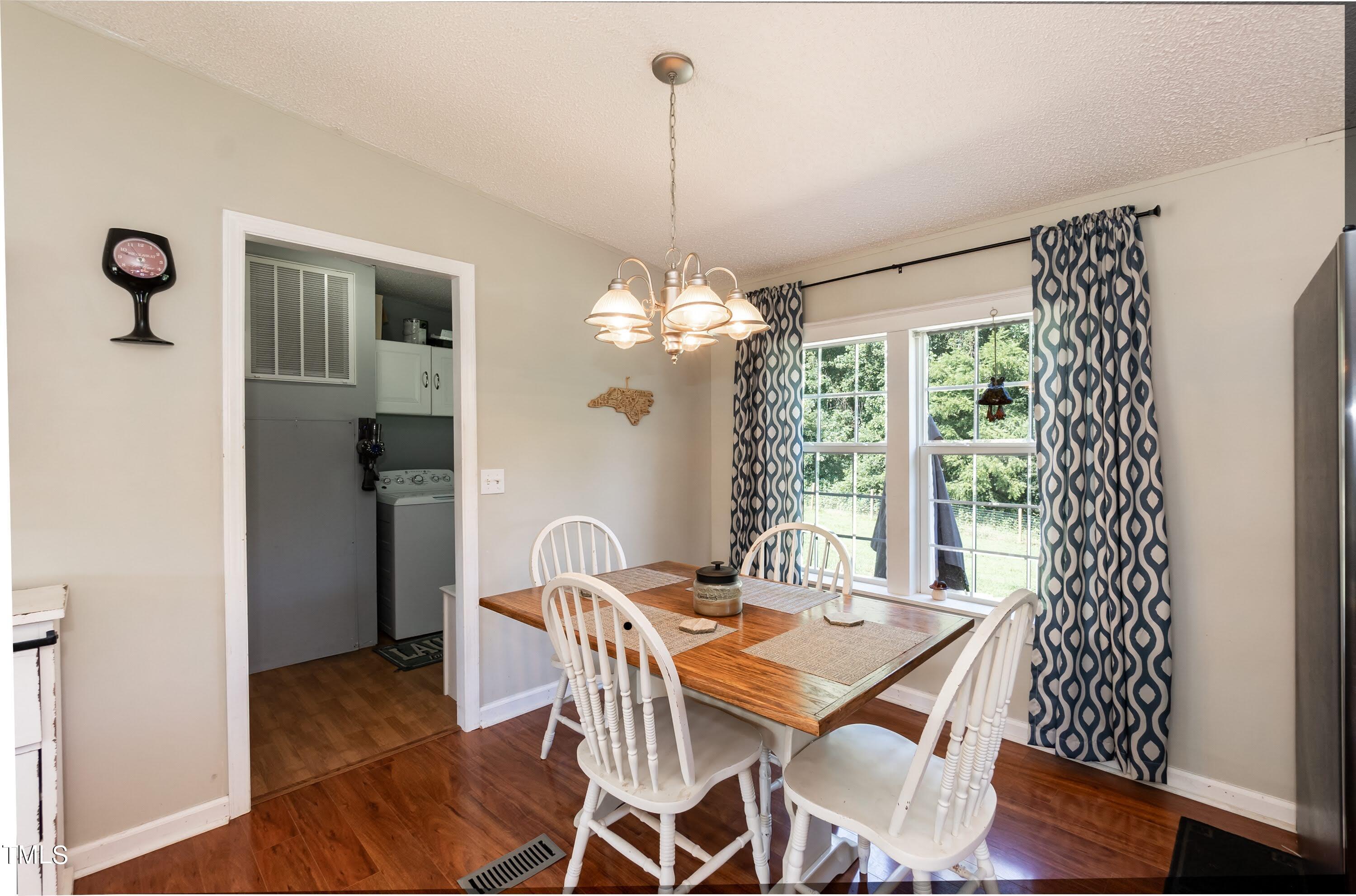 552 Locks Lane Rougemont, NC 27572 - Photo 21 of 45 a dining room with furniture a chandelier and wooden floor
