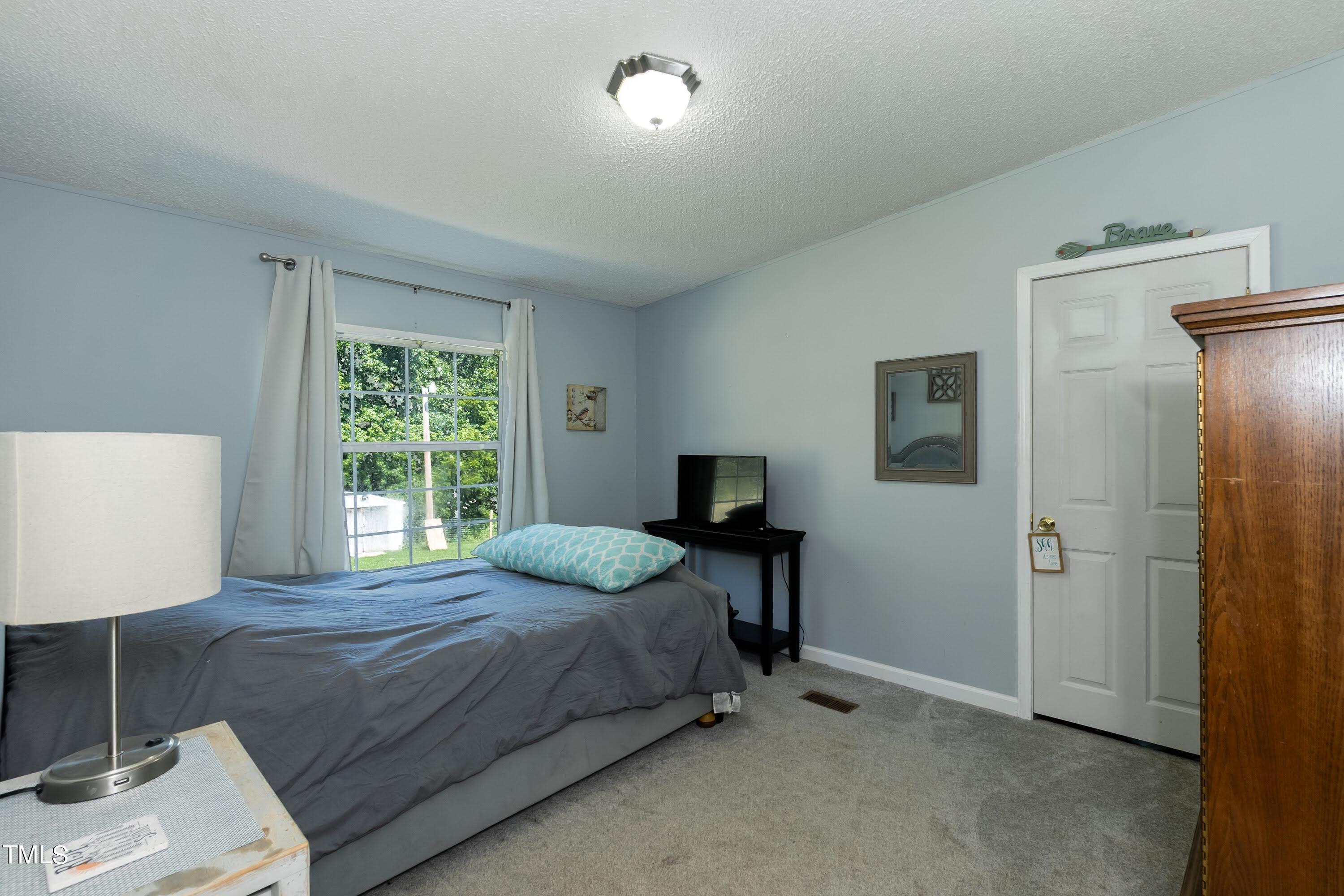 552 Locks Lane Rougemont, NC 27572 - Photo 28 of 45 a bedroom with a bed and a table