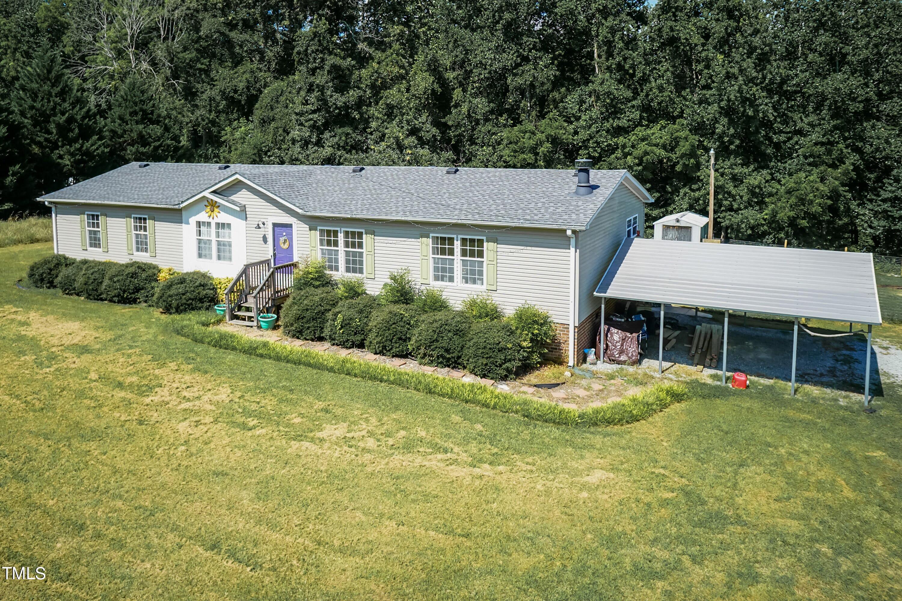 552 Locks Lane Rougemont, NC 27572 - Photo 3 of 45 a front view of a house with a garden and trees
