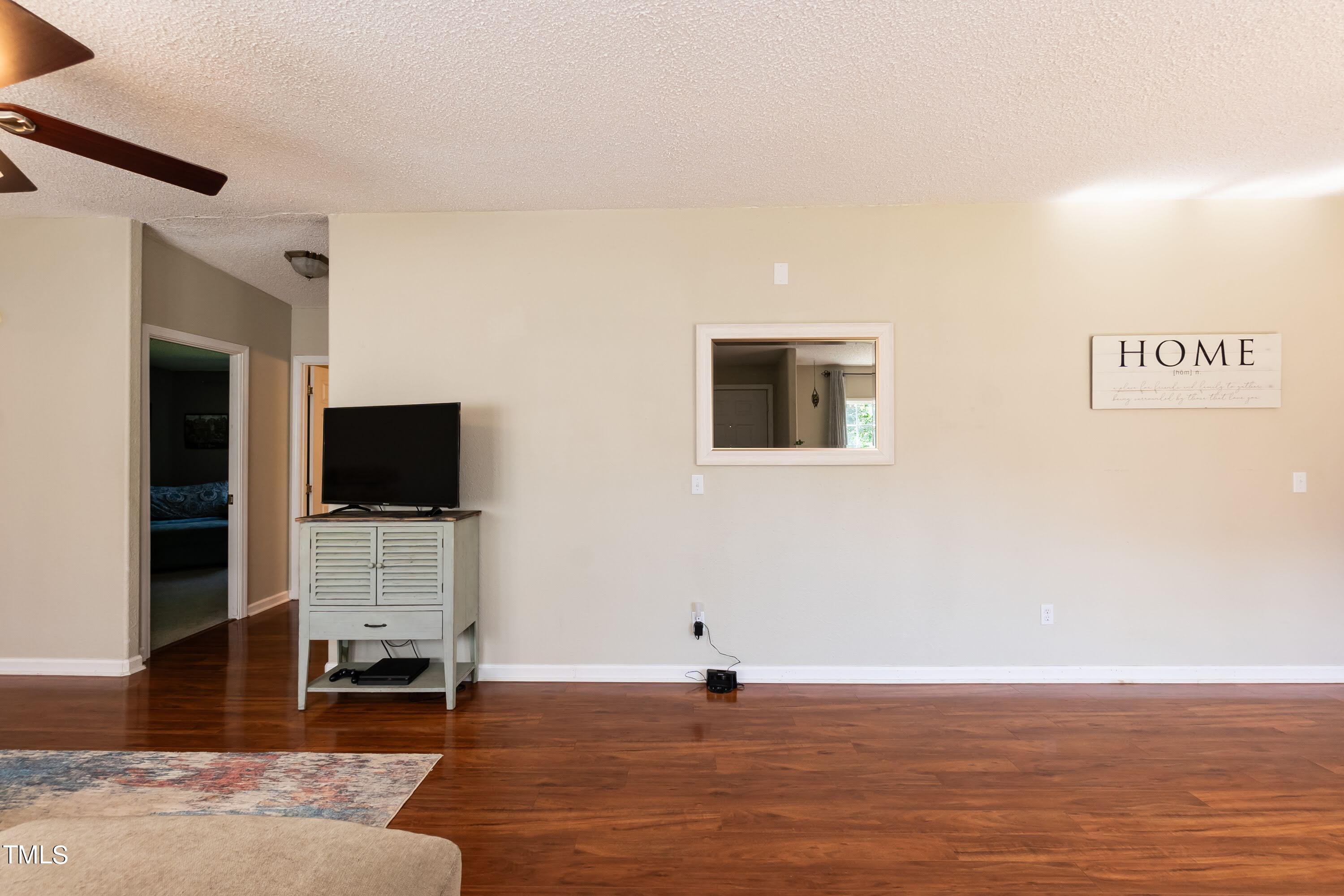 552 Locks Lane Rougemont, NC 27572 - Photo 7 of 45 a view of a livingroom with a flat screen tv wooden floor and a fireplace
