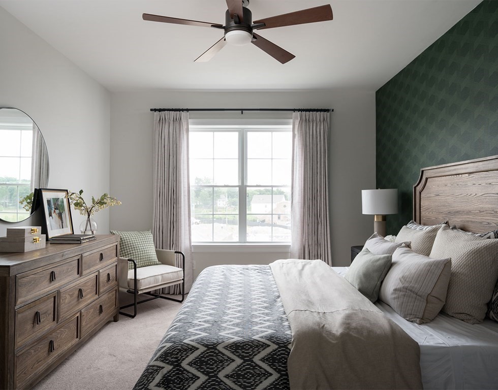 50 Coppersmith Way, Unit 107 Canton, MA 02021 - Photo 11 of 42 a bedroom with a bed and a chandelier