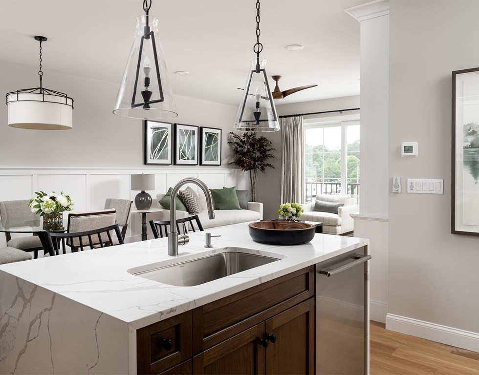 50 Coppersmith Way, Unit 107 Canton, MA 02021 - Photo 16 of 42 a kitchen with a sink a counter and chairs