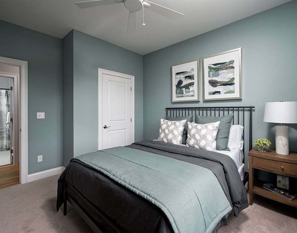 50 Coppersmith Way, Unit 107 Canton, MA 02021 - Photo 27 of 42 a bedroom with a large bed and a lamp on dresser