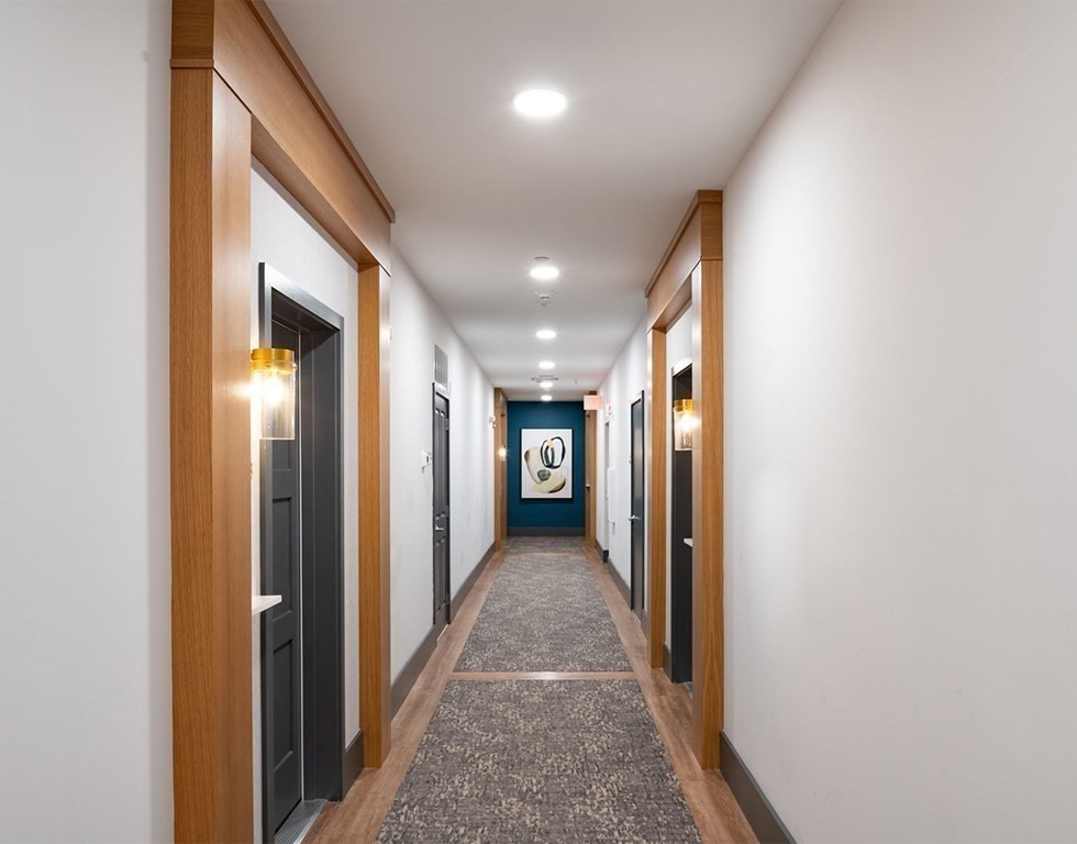 50 Coppersmith Way, Unit 107 Canton, MA 02021 - Photo 29 of 42 a view of a hallway with wooden floor and staircase