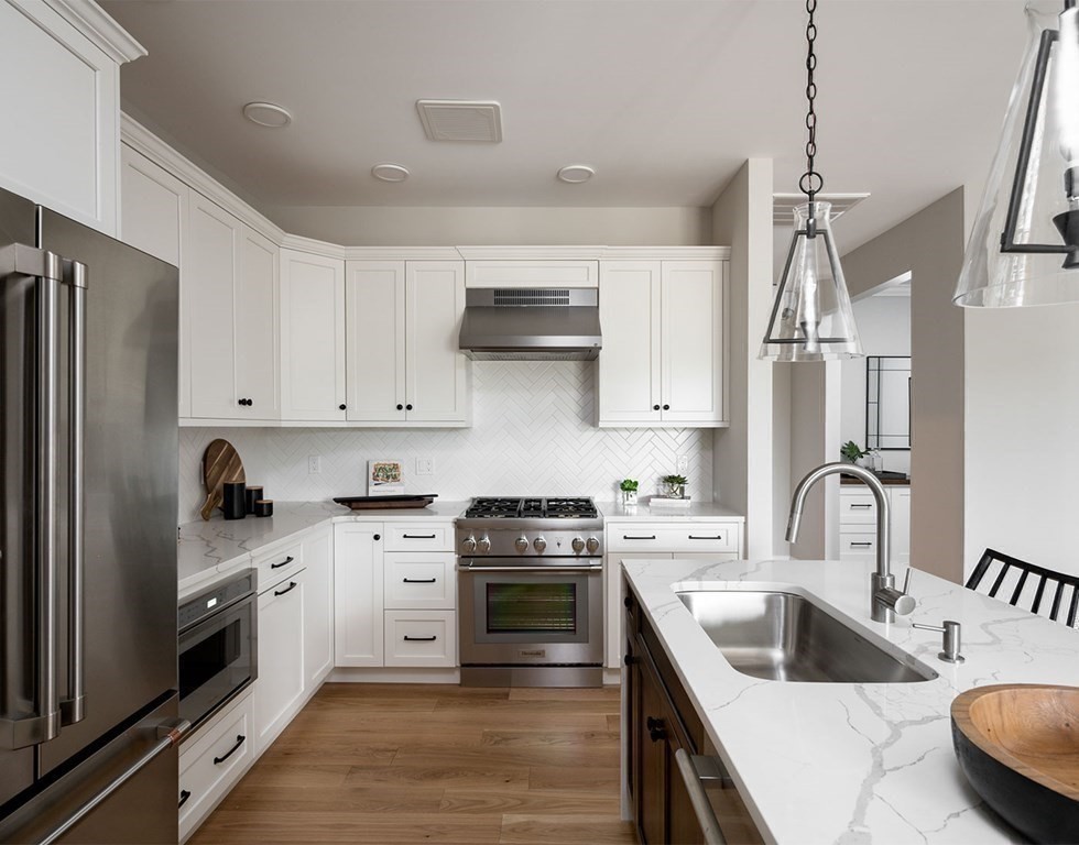 50 Coppersmith Way, Unit 107 Canton, MA 02021 - Photo 9 of 42 a kitchen with stainless steel appliances granite countertop a sink stove and refrigerator