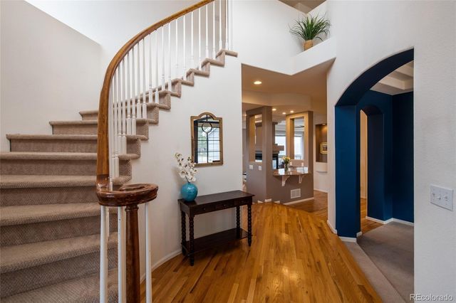 a view of a hallway with wooden floor and staircase