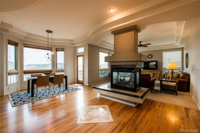 a living room with furniture a fireplace and a floor to ceiling window