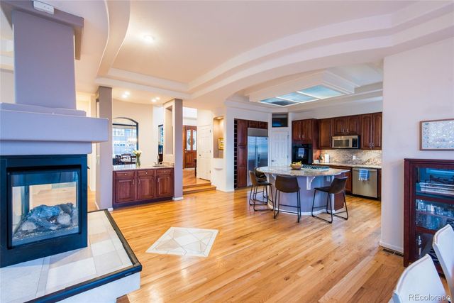 a living room with stainless steel appliances kitchen island granite countertop furniture and a fireplace