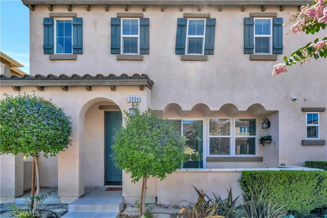a front view of a house with a garden and plants
