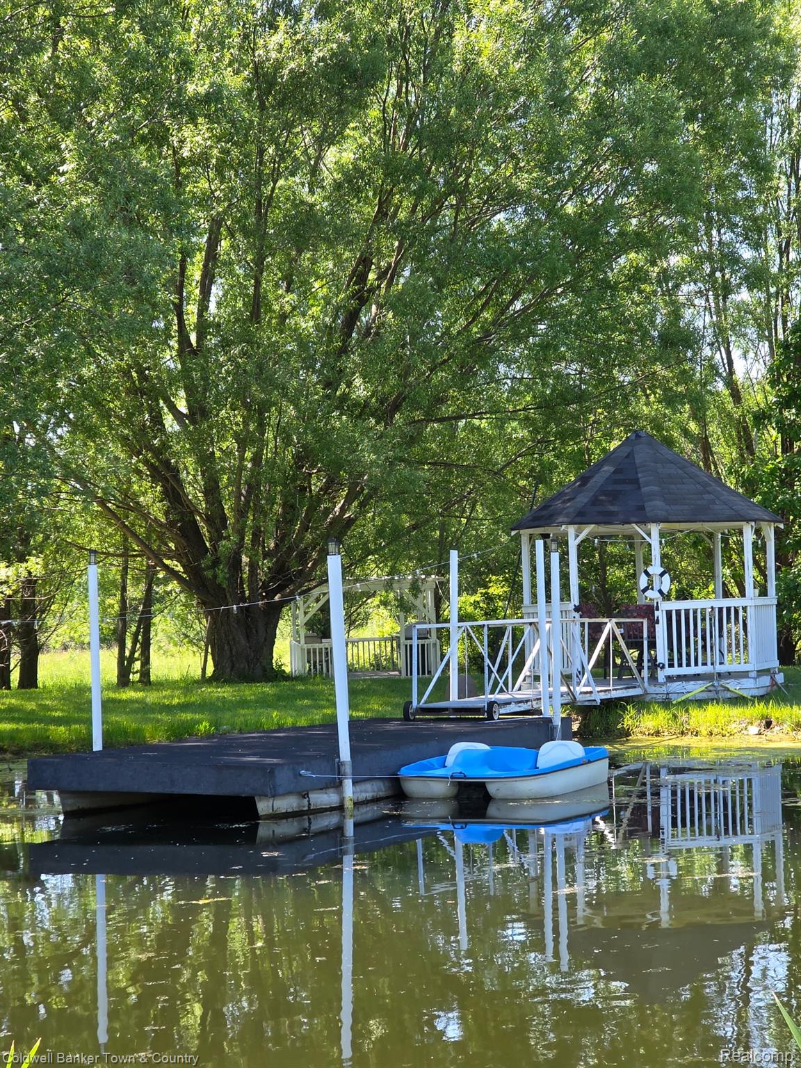 717 North Youngs Road Attica, MI 48412 - Photo 80 of 87 Waterfront gazebo with a dark shingle roof and white railing, accompanied by a floating dock
