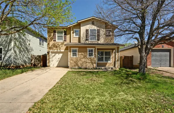 a front view of a house with yard porch and tree