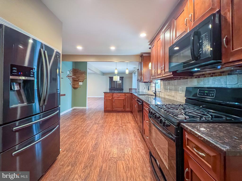 599 Panther Road Warminster, PA 18974 - Photo 12 of 57 a kitchen with stainless steel appliances granite countertop a stove a refrigerator and a wooden cabinets