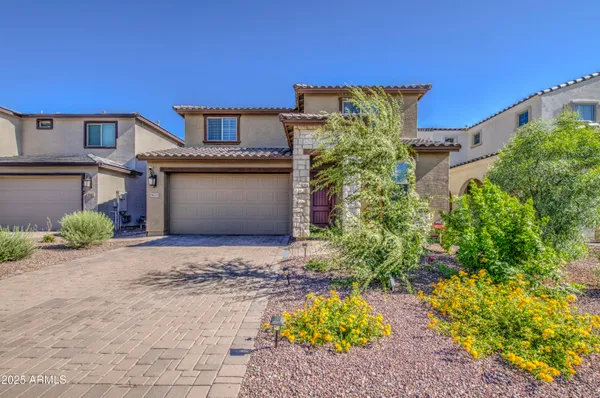 a front view of a house with a yard and a garden